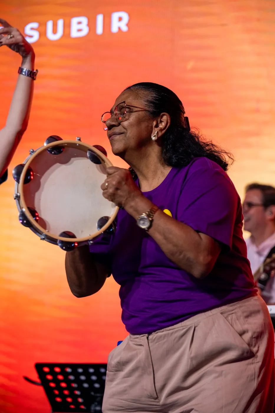 Participante tocando pandeiro durante a celebração
