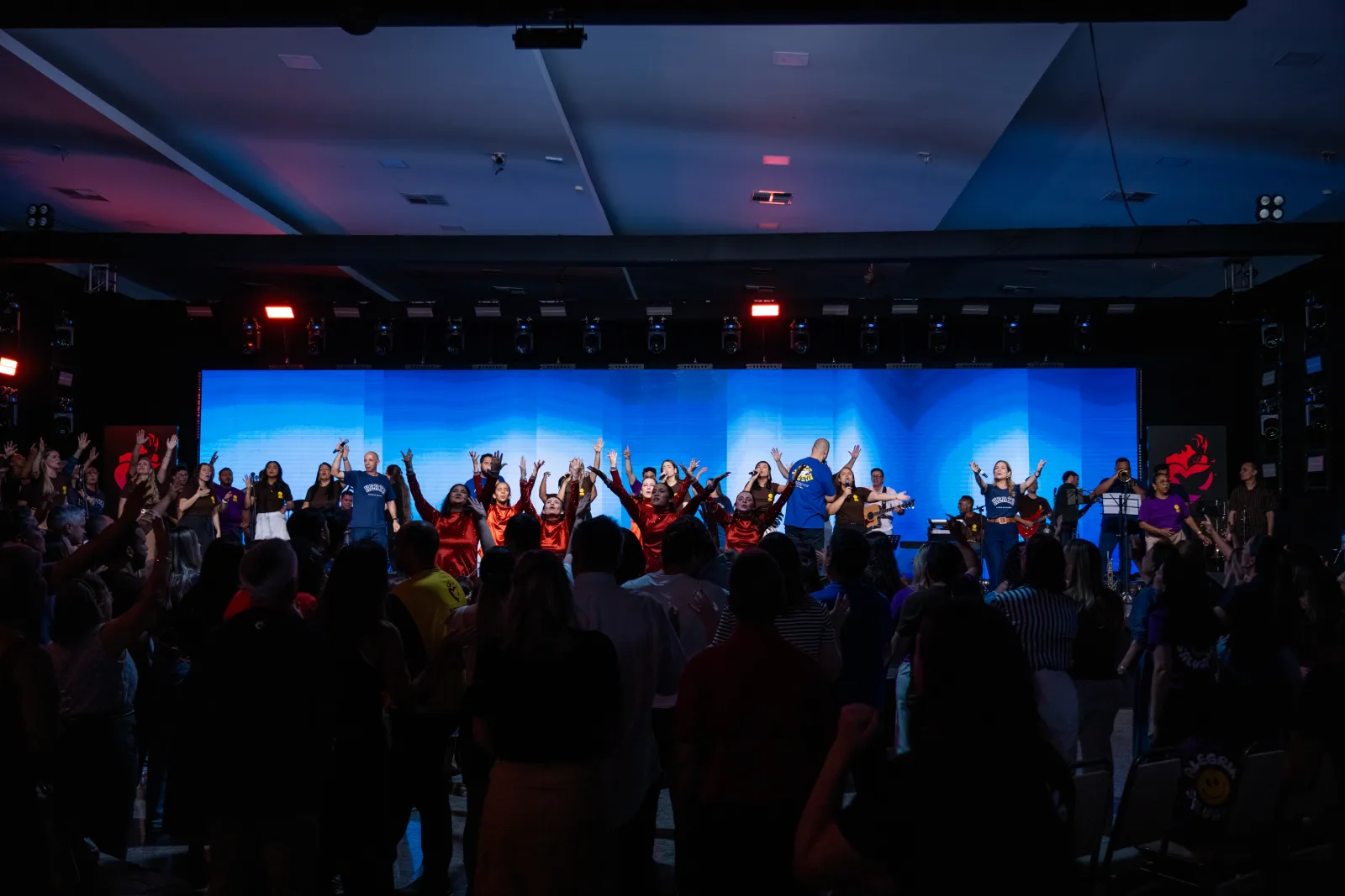 Palco iluminado e público reunido durante a Conferência Hertz 2025